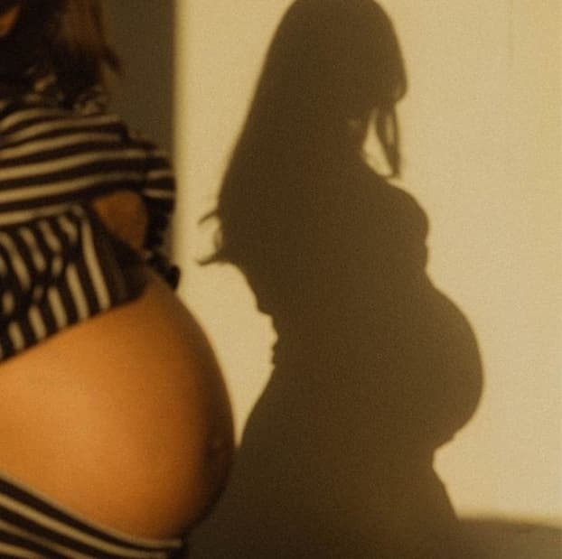 Pregnant woman and her shadow in evening light